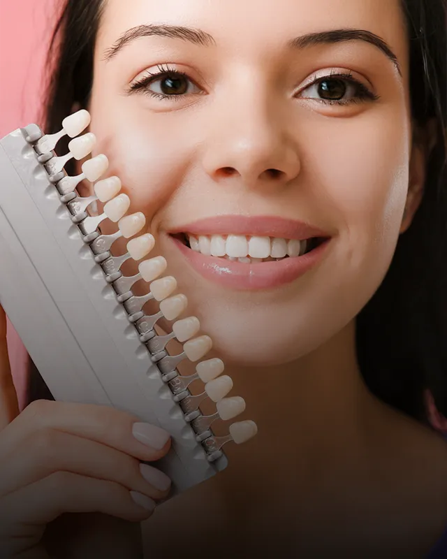 A woman holding a color swatch panel up to her mouth to find the perfect match